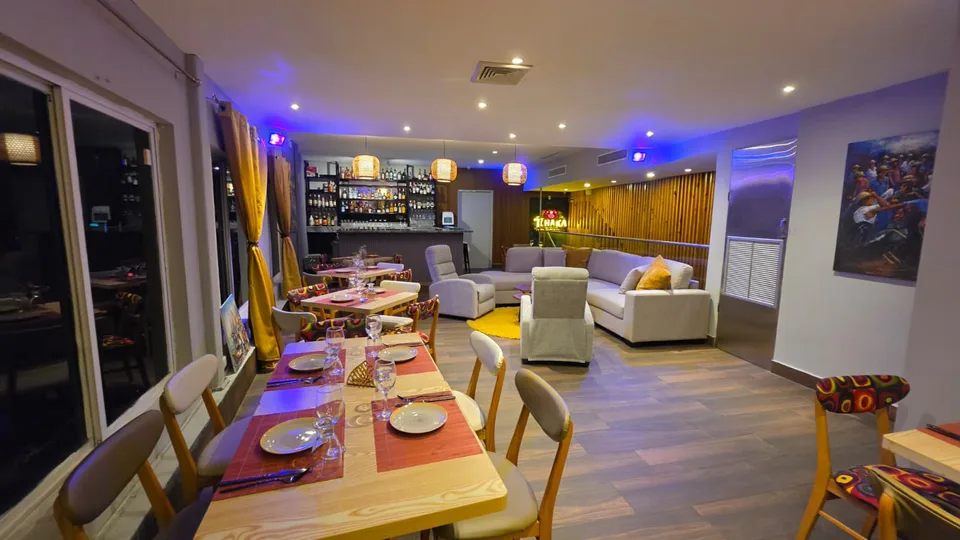 El salón de T’chaka con una mesa puesta, sofás y la barra al fondo