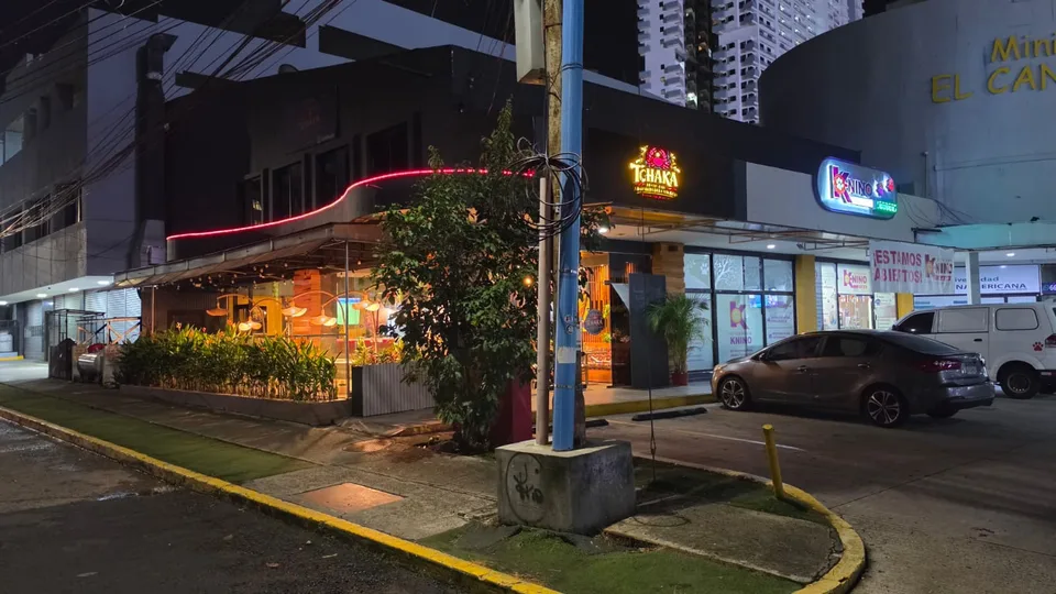 La fachada iluminada de T’chaka en una esquina de El Cangrejo por la noche